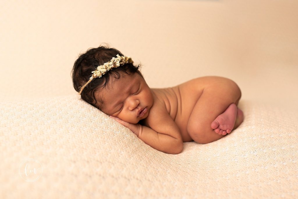 posed newborn on peach blanket